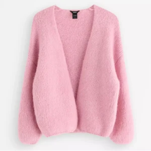 Ljusrosa stickad kofta från Lindex - Supermysig ljusrosa stickad kofta från lindex. Koftan är öppen framtill och har en fluffig, mjuk känsla som gör den perfekt att slänga på sig när det är lite kyligt. Passar dig som gillar chill och comfy vibes. Helt ny, dock så är lappen tyvärr av men super snygg kofta. 