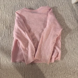 Ljusrosa stickad tröja - Mysig ljusrosa stickad tröja med rund halsringning och långa ärmar. Tröjan har en enkel och clean design med ribbade muddar vid ärmslut och nederkant. Perfekt för dig som gillar en soft och chill stil.