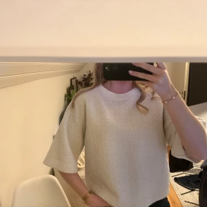 Vit strukturerad blus med vida ärmar - Säljer en vit blus med snyggt strukturerat geometriskt mönster. Modellen har vida trekvartsärmar och en avslappnad passform. Perfekt för dig som gillar stilrena och unika detaljer. Superfin att styla med både jeans och kjol.