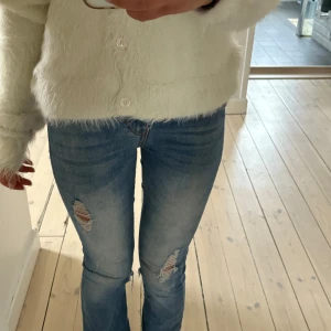Ljusblåa ripped jeans  - Säljer dessa jättesnygga ljusblåa jeans med sjuukt snygga slitningar🥹💓 de är omsydda till bootcut men syns knappast❣️Jeansen är tillverkade i stretchigt denim för en bekväm passform! Innerbenslängd: ca 70cm. De är mid waist men jag brukar vika ner dem 💘