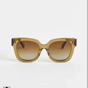 Chimi 08 - Snygga solglasögon från Chimi med fyrkantig form och transparent brun ram. Glasen har en cool tonad effekt som går från mörkbrunt till ljusare. Ramen är tillverkad i slitstark acetat och har diskreta silverdetaljer vid gångjärnen. Perfekt för att höja din stil på soliga dagar. Chimi 08 gröna