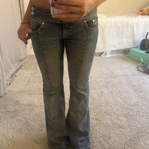 Bootcut jeans Weekday  - Säljer ett par  bootcut jeans från Weekday i en snygg mellanblå tvätt. Jeansen har låg midja, två knappar framtill och inga fickor baktill. Lite stora på mig som har S/M så passar nog bäst på någon med M