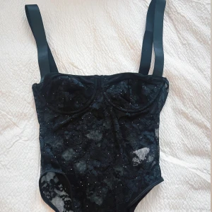 Svart spetsig body med paljetter - Skit snygg men aldrig använd pga försmå för mig vid brösten annars perfekt 