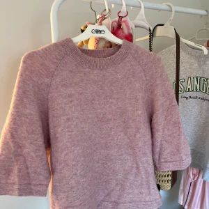 Ljusrosa stickad tröja från & Other Stories - Supermysig ljusros stickad tröja från & Other Stories med rund halsringning och halvlånga ärmar. Perfekt för lager-på-lager och chill dagar. Mjuk och fluffig känsla, passar till både jeans och kjol.