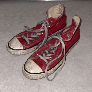 Röda Converse All Star sneakers - Säljer ett par klassiska röda Converse All Star sneakers med vit snörning. Skorna har en vit sula och det ikoniska Converse-märket på sidan. Går att tvättas vid behov.