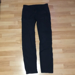 Svarta byxor från Fred Perry - Snygga svarta byxor från Fred Perry med en klassisk design. Byxorna har en rak passform och är tillverkade i ett bekvämt material. Perfekta för en stilren look.