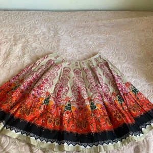 Mönstrad kjol från Dorothy Perkins - Säljer en färgglad kjol från Dorothy Perkins med ett vackert blommönster i rosa, orange och svart. Kjolen har en dragkedja i sidan och är perfekt för att liva upp garderoben. Den har en vid passform och är i en bekväm längd. Har använt den en enstaka gång annars har den bara legat i garderoben. Priset går att diskutera💞