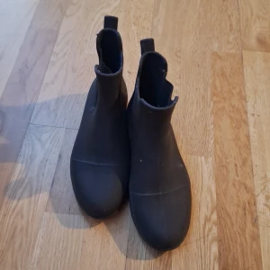 Svarta ridskor - Säljer ett par svarta boots med rund tå och elastiska sidor för enkel påtagning. Perfekta för både regniga och torra dagar.