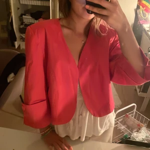 Rosa kappa med trekvartsärm - Snygg rosa kappa med trekvartsärm och öppen front. Perfekt för att lägga till en färgklick till din outfit. Passar bra till både vardag och fest.