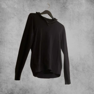 Svart långärmad tröja med dragkedja - Snygg svart långärmad tröja med dragkedja vid halsen. Perfekt för en stilren look och passar bra till både jeans och chinos. Tröjan har en enkel design som gör den lätt att matcha med andra plagg.