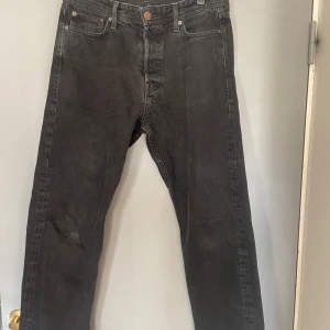 Svarta jeansbyxor med lös passform - Säljer ett par svarta jeansbyxor med lös passform. Byxorna har en klassisk design med fem fickor och knappgylf. Perfekta för en avslappnad stil.