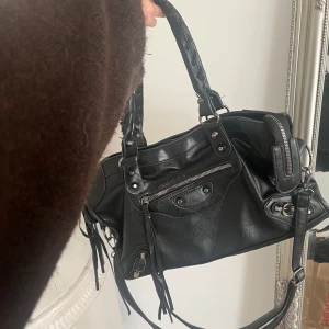 Svart handväska - Säljer denna väska! Använd men fortfarande i ett bra skick! Lite trasig på sidan  vid bandet (se bilden) men annars väldigt fint skick!❤️ kom privat för fler bilder