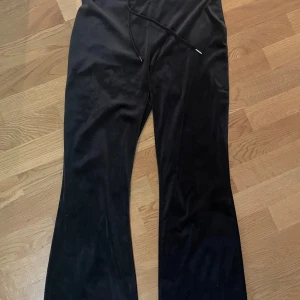 Svarta mjukisbyxor med snörning - Säljer ett par svarta mjukisbyxor med snörning i midjan och bakfickor. Byxorna har en loose passform och är perfekta för en avslappnad stil.