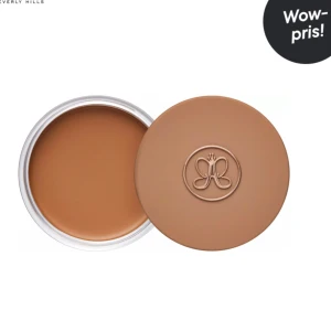 Krämbronzer Anastasia  - Säljer en krämbronzer i nyansen Amber. Produkten kommer i en rund burk med skruvlock och har en mjuk, krämig konsistens som ger en naturlig solkysst look. 30g