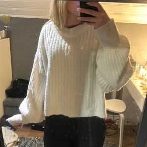 Vit ribbad stickad tröja - Säljer en mysig vit stickad tröja med ribbad struktur. Tröjan har en lös passform och långa ärmar. Ärmarna är lite större. 