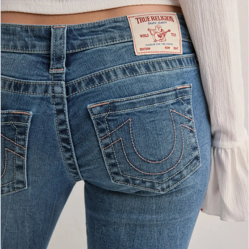 Snygga blå jeans från True Religion med bootcut-stil och låg midja. De har klassiska framfickor och märkets ikoniska broderade bakfickor. De är uppsydda på jeans bolaget och passar mig som är 155 perfekt i längden!!. Farkut & Housut.