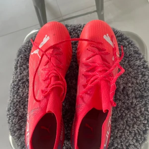 Röda fotbollsskor från Puma - Snygga röda fotbollsskor från Puma med snörning och vita detaljer. Använda en gång, säljer då dem är något för stora för mig