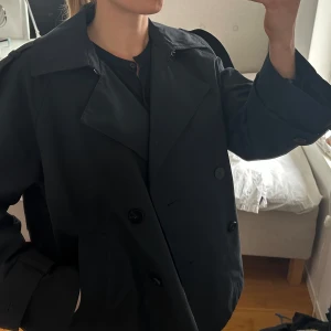 Blå trenchcoat från Massimo Dutti - Snygg blå trenchcoat från Massimo Dutti med dubbelknäppning och klassisk krage. Använd ett fåtal gånger så jättefint skick!