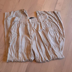 Beige linnebyxor från Gina Tricot - Snygga beige linnebyxor från Gina Tricot. Storlek 36, Inga skador men varit lite långa för mig så är en ytterst liten färgskillnad längst ner i hälen. 