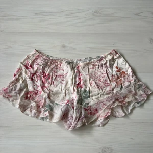 Blommiga volangshorts från Intimissimi - Shorts med blommigt mönster i rosa. De har elastisk midja och volangkant nedtill. Shortsen är från Intimissimi. Pris kan alltid diskuteras ❤️