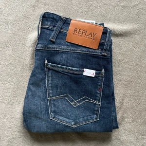 Replay Anbass slim jeans blå denim - Helt nya jeans från Replay i modellen Anbass. Jeansen har slim passform, storlek 28/34 men passar dig som är runt 170cm lång och har under 82cm i midjan 