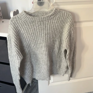 Grå stickad tröja från 157 XS - Mysig grå stickad tröja från 157 i storlek XS. Tröjan har en ribbad struktur, rund halsringning och långa ärmar. Perfekt för lager-på-lager och chill höst- och vinterdagar. Enkel att matcha med jeans eller kjol. Använt ett fåtal gånger, inget som märks☺️