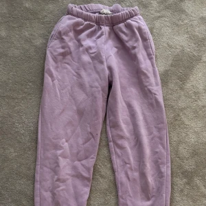 Ljuslila mjukisbyxor med resår - Mysiga ljuslila mjukisbyxor med resår i midjan och benslut samt snörning i midjan. Tillverkade i mjuk bomull, perfekta för chill dagar eller när du vill vara extra bekväm. Klassisk loose passform och enkel design utan mönster.