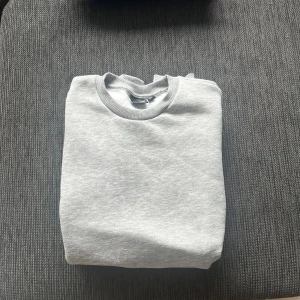 Grå sweatshirt från Only & Sons - En stilren grå sweatshirt från Only & Sons med rund halsringning och ribbade muddar. Tröjan är i mjuk bomullsblandning och har en klassisk passform som funkar till allt. Perfekt till någon sommarkväll och för sommarn generellt då den är grå och clean