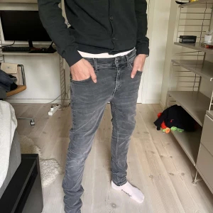 Tiger of Sweden jeans - Snygga grå jeans från Tiger of Sweden i modellen Evolve. De har en skinny passform och klassisk femficksdesign. Jeansen är i stretchigt denim och har en mörkgrå tvätt som ger en cool vibe. Perfekta till sneakers eller boots.