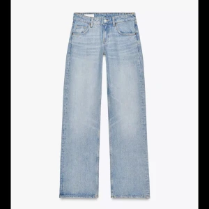 Ljusblå wide jeans med låg midja - Säljer ett par ljusblå jeans med snygg tvätt och klassisk femficksdesign. Jeansen har låg midja och breda, raka ben för en avslappnad och trendig look. Tillverkade i jeansmaterial som känns både slitstarkt och bekvämt.