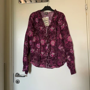 Odd molly skjorta  - Otroligt vacker skjorta o lila och rosa färger med ett fint blom mönster. Från märket Odd Molly i storlek 0 som ungefär motsvarar en Storlek XS. Kanske rymlig i storlek. Helt ny med tags/ prislapp fortfarande kvar. 