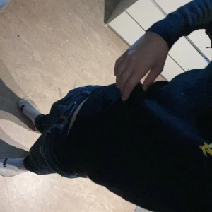 Mörkblå v-ringad tröja från Lyle&scott - Snygg mörkblå v-ringad tröja från Lyle&scott med den klassiska gula loggan broderad på bröstet. Tröjan har lång ärm och är gjord i mjuk bomull, perfekt för lager-på-lager och chill stil. Det står xl men den har krympt i tvätt 