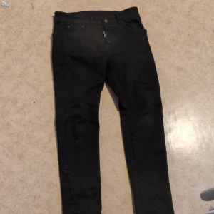 Svartajeans från Dsquared2 - Snygga svarta skinny jeans från Dsquared2 med klassisk femficksdesign och cool Dsquared2-patch bak i midjan. Jeansen har smal passform och är tillverkade i stretchigt bomullsmaterial för en bekväm känsla. Perfekta för dig som gillar en stilren och modern look. 