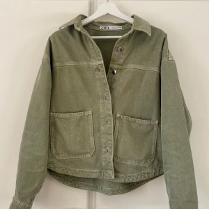 Jeansjacka militärgrön Zara  - Säljer en snygg militärgrön jeansjacka  från Zara. Storleken är Xs men den är åt def större mer hållet. Den har väldigt  använts få gånger och är i jättebra skick och perfekt under sommaren/hösten. 