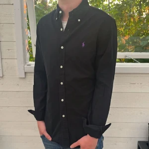 Svart Ralph lauren skjorta - Hej säljer nu min fina Ralph lauren skjorta i storlek M. Den är i bra skick och kommer vara otroligt snygg nu i vår och framåt sommaren. Nypris cirka 1600kr! Vi kommer att sälja liknande produkter nu i vår och närmare sommar så glöm inte följa profilen!🌊🍾