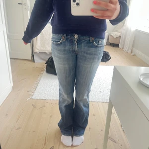 Blå bootcut jeans från 7 For All Mankind - Snygga blå bootcut jeans från 7 For All Mankind med klassisk femficksdesign och ljusa slitningar. Jeansen har låg midja och är utsvängda. Midjemått: 80 cm | innerbenslängd: 82 cm | uppskattad strl, står ingen W inuti byxan, men passar mig som vanligtvis har w27 eller w28
