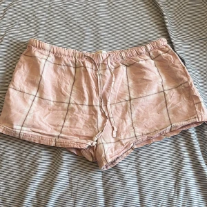 Rutiga rosa shorts från Gina Tricot - Snygga rosa shorts från Gina Tricot med rutigt mönster. De är tillverkade i mjuk bomull och har en avslappnad passform, perfekta för varma dagar. Elastisk midja för extra komfort. Köpta på barnavdelningen men skulle säga att de sitter som en XS. Lågmidjade. Pris är diskuterbart. Hör av dig om du vill ha mer info/bilder.