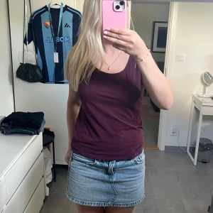 Vinröd kortärmad topp från H&M - Enkel och stilren vinröd topp från H&M Basic med rund halsringning och korta ärmar. Tillverkad i mjuk bomull som känns skön mot huden. Perfekt att matcha med jeans eller kjol för en clean look.