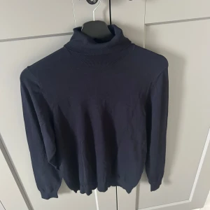 Mörkblå stickad tröja från Zara - Snygg mörkblå tröja som är stickad från Zara. Säljer denna tröjan för att den inte används. Den är som helt ny. Bara att skriva vid funderingar på nått eller om man vill ha fler bilder. Kragen kan man vika eller så viker man inte den och den är hela vägen upp till halsen eller så viker man den och gör den kortare.