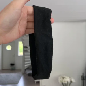 Svart brett hårband - Enkelt och stilrent svart diadem i mjuk bomull. Bred modell som sitter bekvämt och håller håret på plats. Perfekt för att ge en clean look till din outfit. Passar både till utsläppt och uppsatt hår. Önskar du veta exakta mått? Tveka inte att höra av dig!