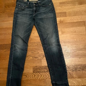 Jacob Cohen mörkblå skinny jeans - Snygga mörkblå jeans från Jacob Cohen med klassisk femficksdesign och diskret slitning. Modellen är skinny fit med normal midja och har en brun patch med logga bak. Perfekta för dig som gillar stilrena och bekväma jeans med exklusiv känsla.