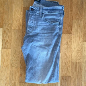Grå jeans från Jack and Jones  - Säljer dessa grå Jack and Jones jeans. Storlek 32/32 Slim/Glenn i väldigt bra skick fast med en liten fläck på benet.  
