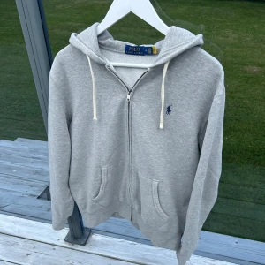 Polo Ralph Lauren hoodie - Grå hoodie från Polo Ralph Lauren, skick 9,5/10 nästan som ny, inga defekter, väldigt skönt material, storlek M passar 178-189, äkta med qr, nypris +2200, priset går att diskutera, kom med frågor och bud//Rl_Supply