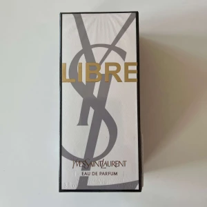 Yves Saint Laurent Libre EdP 90ml - Yves Saint Laurent Libre Eau de Parfum i elegant vit och svart kartong med guldiga detaljer. Doften är känd för sin fräscha och blommiga karaktär, perfekt för dig som gillar lyxiga och moderna parfymer. Flaskan rymmer 90 ml.