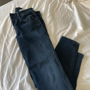 Replay Anbass jeans mörkblå, stl 29 - Säljer ett par snygga Replay Anbass jeans i mörkblå tvätt. Klassisk femficksmodell med raka ben och normal passform. Jeansen har bälteshällor och är tillverkade i mjukt denimtyg som sitter skönt hela dagen.