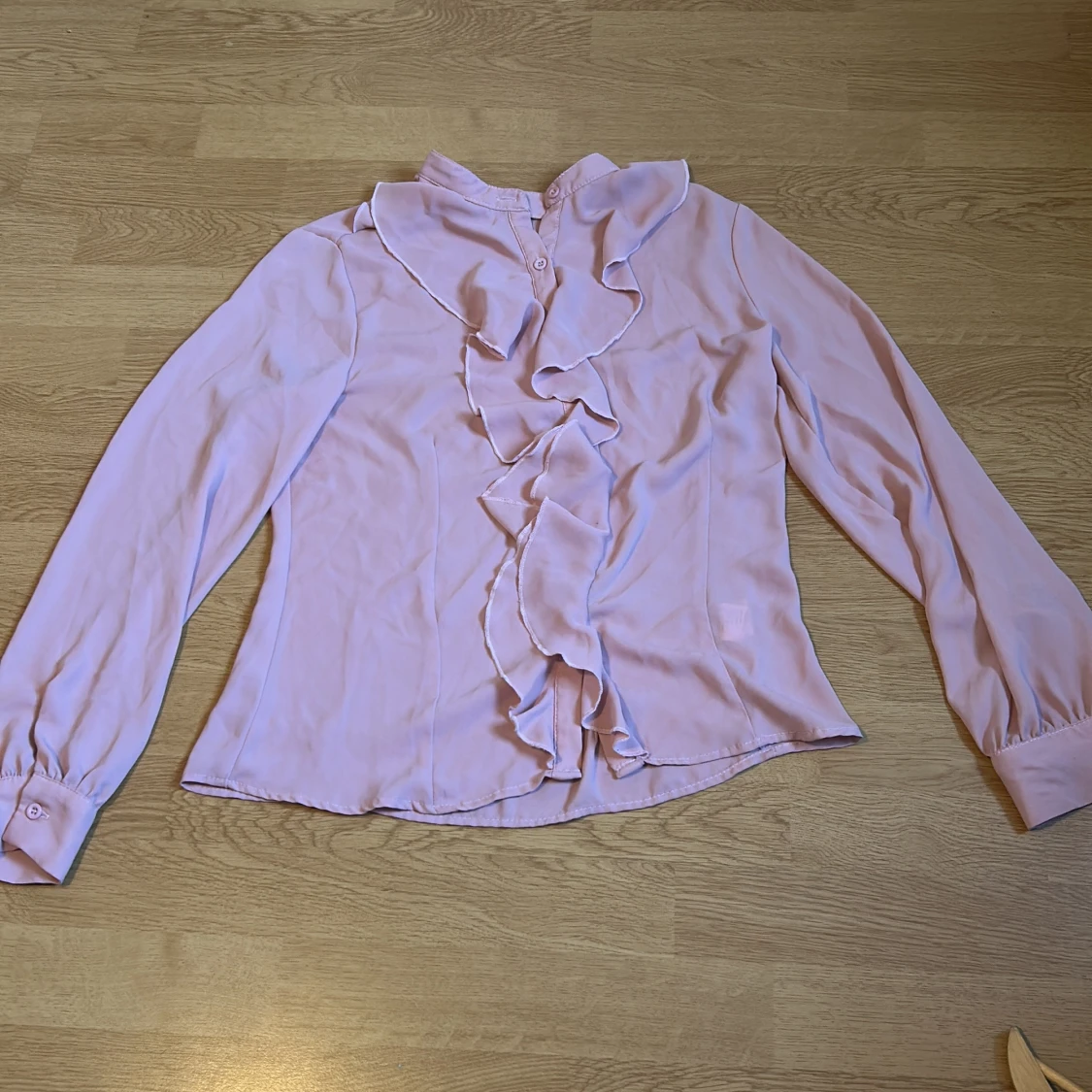 Ljusrosa blus med volang och knappar