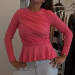Rosa långärmad peplum topp - Säljer en snygg rosa långärmad topp med peplumskärning. Toppen har rund hals och markerad midja som ger en feminin siluett.  Lappen är kvar💕