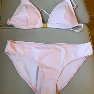Ljusrosa bikini från Juicy Couture XL - Superfin och oanvänd ljusrosa bikini från Juicy Couture med guldigt spänne framtill och broderad JUICY-text bak på trosan. Klassisk trekantsmodell upptill och enkel bikiniunderdel. Perfekt för stranden eller poolen i sommar!                                            Ny pris ligger på 100$ (cirka 1000kr pris kan diskuteras) 