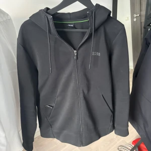 Svart hoodie från Hugo Boss - Svart hoodie från Hugo Boss | storlek M | okej skick men är urtvättad därav priset