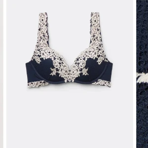 intimissimi bh  - Supersnygg mörkblå bh med krämvit spets och blommiga detaljer. Axelbanden och kanterna är täckta av spets som ger en romantisk vibe. Perfekt för dig som vill ha något extra under outfiten.